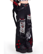 Black Y2K aesthetic pants with rips, bones, and decorative hardware.