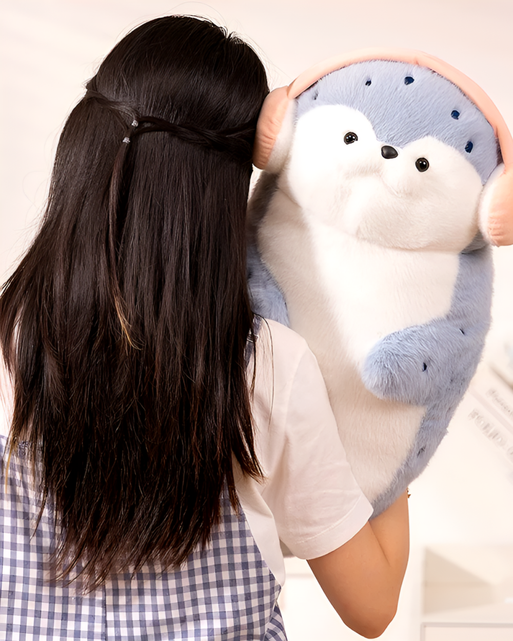 A light blue Kawaii Seal Plushie is being held by a person.