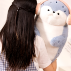 A light blue Kawaii Seal Plushie is being held by a person.