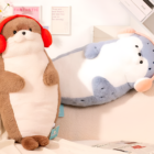 Two Kawaii Seal Plushies, one brown and one blue, sitting on a bed.