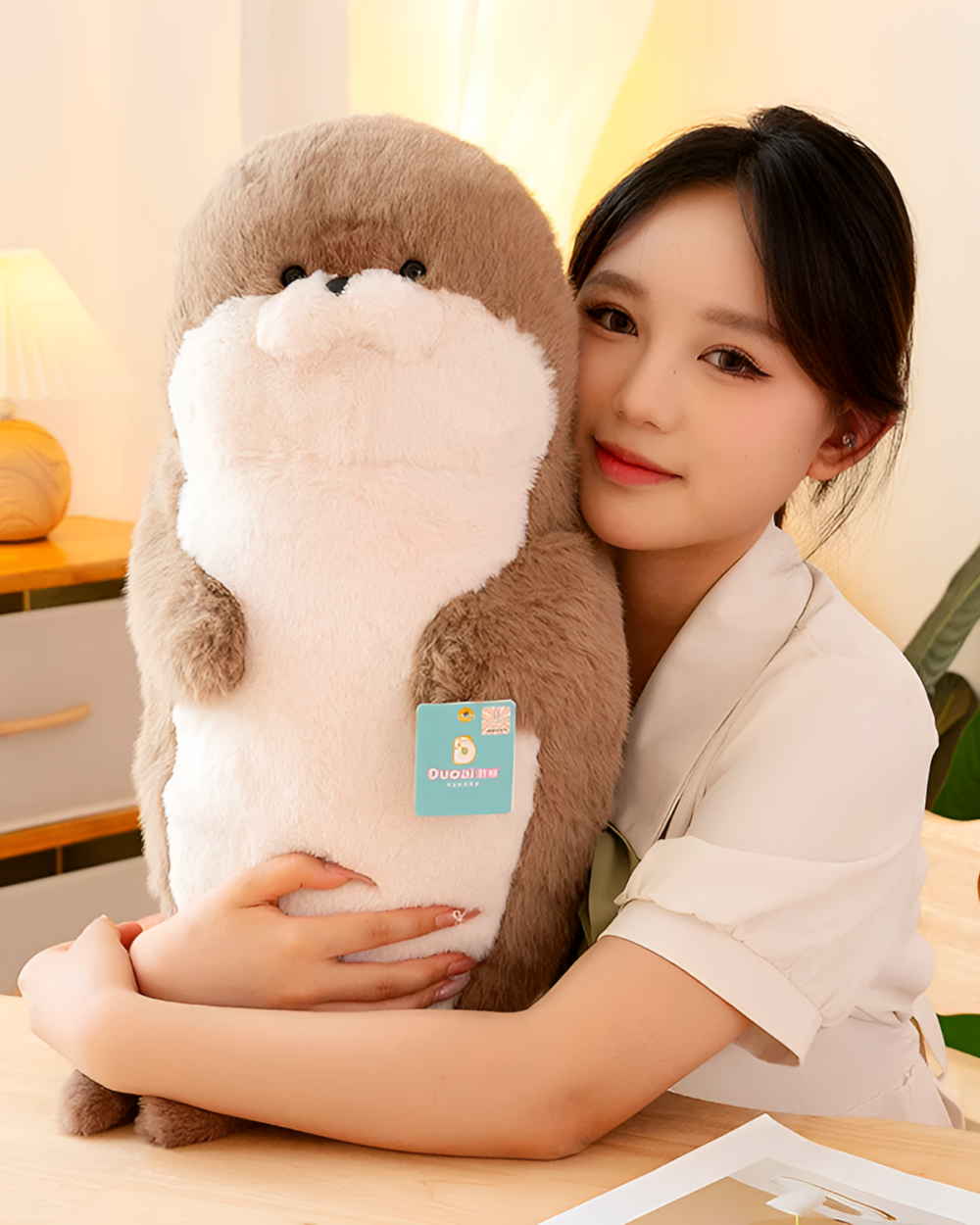 A Kawaii Seal Plushie, a soft and cuddly stuffed animal, held by a woman.