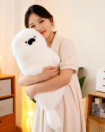 Kawaii Seal Plushie held by a person in a cozy room setting.