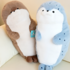 Two Kawaii Seal Plushies, one brown and one blue, displayed on a white pillow.