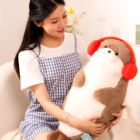 A Kawaii Seal Plushie, brown and white, with red headphones, held by a woman.
