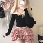 Pink Yume Kawaii Aesthetic ruffled mini skirt with lace trim, layered over a black top.