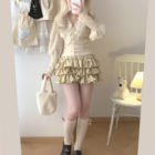 Yume Kawaii Aesthetic ruffled mini skirt outfit featuring a cream-colored top and socks.