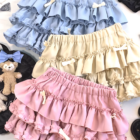 Stack of Yume Kawaii Aesthetic ruffled mini skirts in pastel colors, featuring a layered ruffles design and bow accents.
