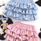 Two Yume Kawaii Aesthetic ruffled mini skirts, one light blue and one pink, with bows. Props included.
