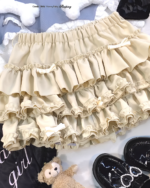 Yume Kawaii Aesthetic ruffled mini skirt, light beige, layered ruffles, detailed close-up.