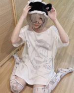 Model wearing a Cat Girl Oversized T-Shirt with anime cat ears and a maid headband.