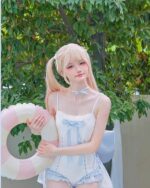 Model wearing a blue Lolita Inspired Swimwear outfit with a pink floatie.