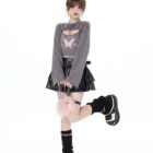 Woman wearing a Fairy Grunge Set: grey cropped sweater with butterfly graphic and a black ruffled skirt.