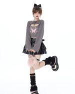 Woman wearing a Fairy Grunge Set: grey cropped sweater with butterfly graphic and a black ruffled skirt.