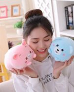 Pink and blue Squishy Animal Plushies - Mini Plush Edition, held by a woman.