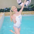 Model wearing a white Lolita Inspired Swimwear in a pool, holding a life preserver.