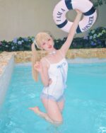 Model wearing a white Lolita Inspired Swimwear in a pool, holding a life preserver.