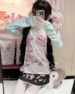 Long Sleeves Mezzo Piano T-Shirt featuring pastel pink and character illustrations.