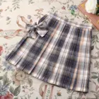 JK Plaid Skirt, a pleated summer skirt with a bow tie detail on a floral background.
