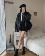 Woman wearing a black Korean Style Jacket with a collared shirt and black pants.