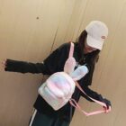 Pink and white Rabbit Ears Plush Backpack shown being carried by a person.