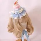 Sweet Lolita Hairpin adorns blonde wig, featuring a miniature cake and ruffled blue lace design.