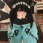 Close-up of a Fish Bone Hoodie - Harajuku Aesthetic, featuring a teal body and star accents.