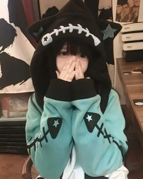 Close-up of a Fish Bone Hoodie - Harajuku Aesthetic, featuring a teal body and star accents.