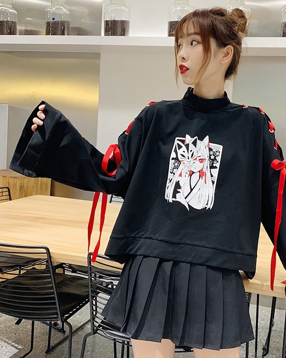 Black Kitsune Bowed Sweatshirt with anime graphic, featuring red accents and ruffled skirt.