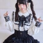 Lolita Style Dark Set featuring a white blouse with black lace and a black skirt with ruffles. A corset completes the gothic aesthetic.