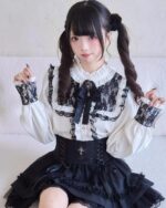 Lolita Style Dark Set featuring a white blouse with black lace and a black skirt with ruffles. A corset completes the gothic aesthetic.