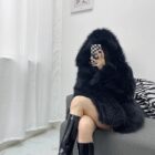 Woman wearing a Thick Fluffy Faux Fur Coat, black boots, and a modern interior setting.