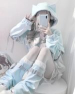 A person wearing a light blue Kawaii Gamer Hoodie and cat ear hood.