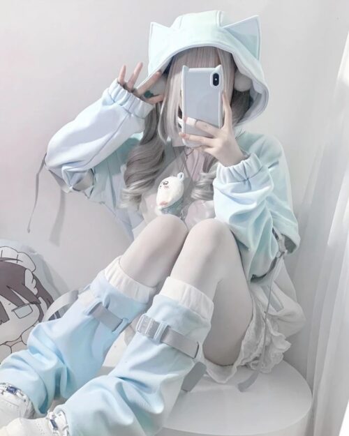 A person wearing a light blue Kawaii Gamer Hoodie and cat ear hood.