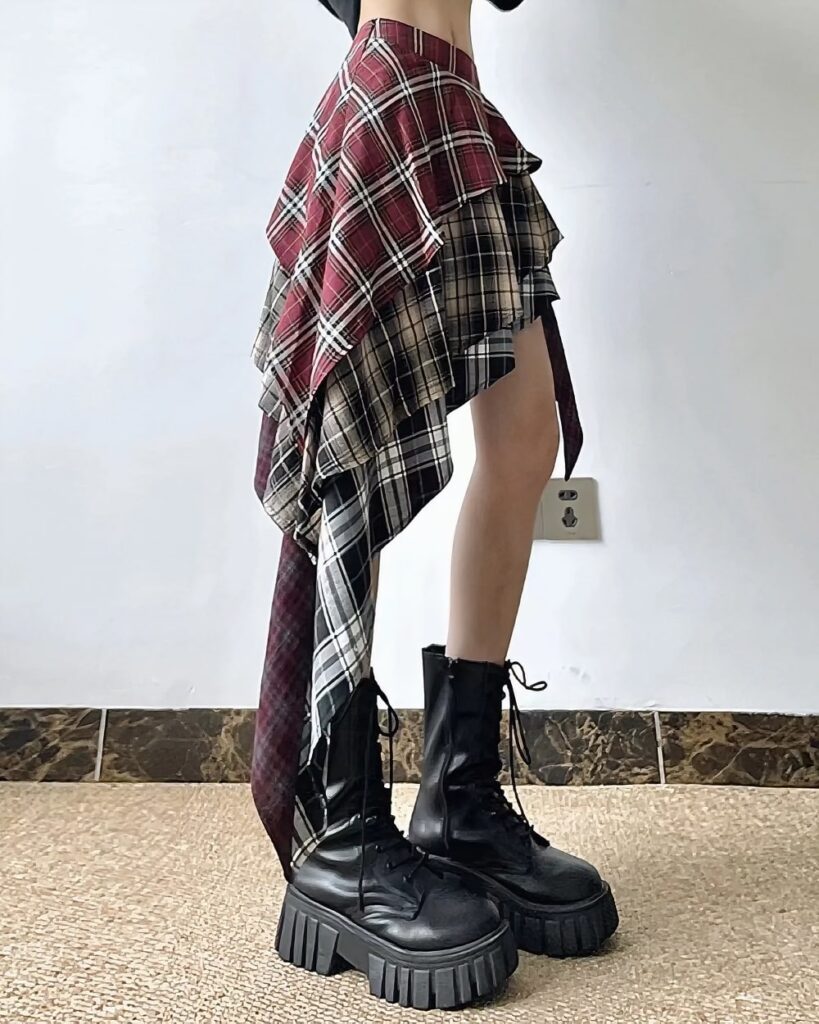 Patched plaid Grunge Aesthetic Skirt, featuring a distressed, asymmetrical design and layered fabric.