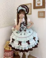 A young woman wearing a Frilly Ribbon Dress - Hime Lolita Dress, featuring a pale blue and brown color scheme with ruffles and bows.