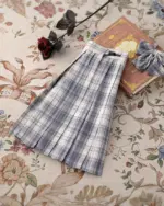 A JK Plaid Skirt, featuring a blue and gray plaid pattern, shown on a patterned background.