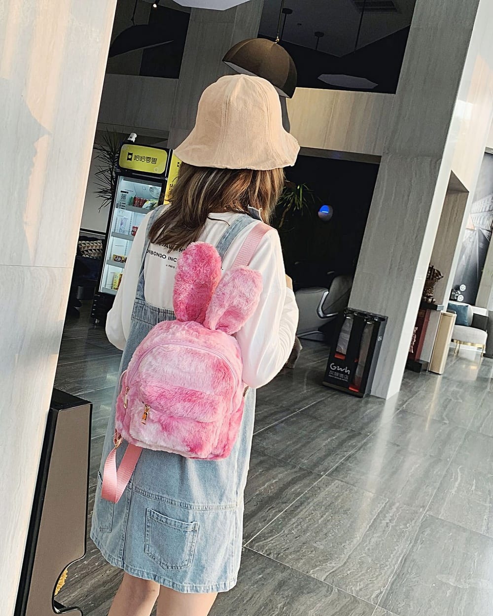 Pink Rabbit Ears Plush Backpack worn by a person, casual style.