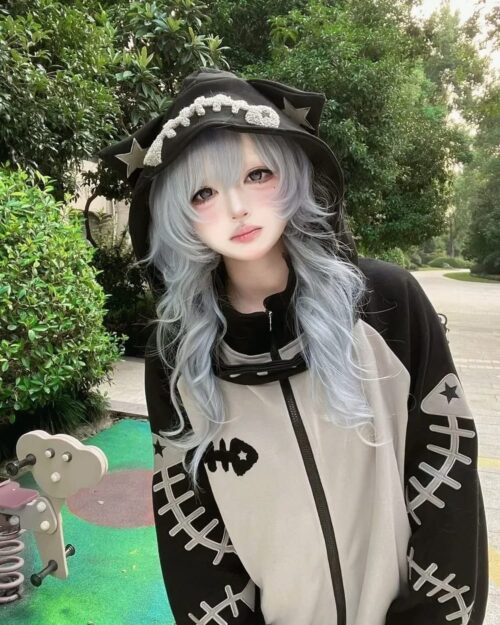 Person wearing a Fish Bone Hoodie and a hat with a skull design.