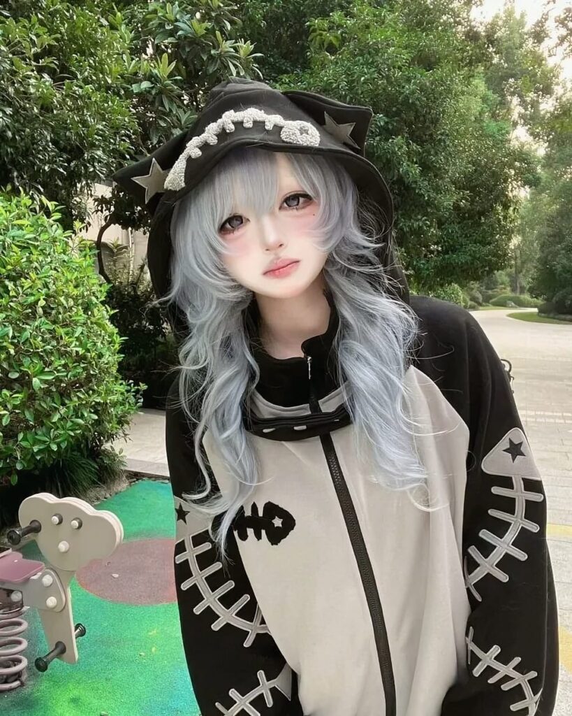 Person wearing a Fish Bone Hoodie and a hat with a skull design.