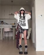 Model wearing a Grunge Aesthetic Skirt and plaid shirt layered over a graphic tee.