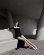 Woman wearing Anime Nun Costume - Halloween Edition, black robe, gloves, and veil.