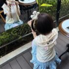 Woman wearing a blue Kuma Zip Up Hoodie - Jojifuku Hoodie at an outdoor cafe.