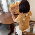 Woman wearing a Kuma Zip Up Hoodie - Jojifuku Aesthetic, brown color, casual style.