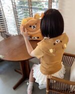 Woman wearing a Kuma Zip Up Hoodie - Jojifuku Aesthetic, brown color, casual style.