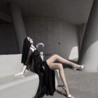 Woman wearing Anime Nun Costume - Halloween Edition, black gown, gloves, and heels.