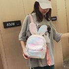 A pink Rabbit Ears Plush Backpack being carried by a person.
