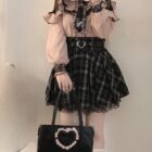 Woman wearing a Jirai Kei Blouse with ruffles and lace details, paired with a plaid skirt and accessories.