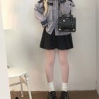 Woman wearing a Jirai Kei Blouse with lace details and a black pleated skirt.