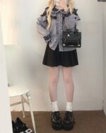 Woman wearing a Jirai Kei Blouse with lace details and a black pleated skirt.