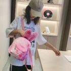 Pink Rabbit Ears Plush Backpack carried by a woman in a store.
